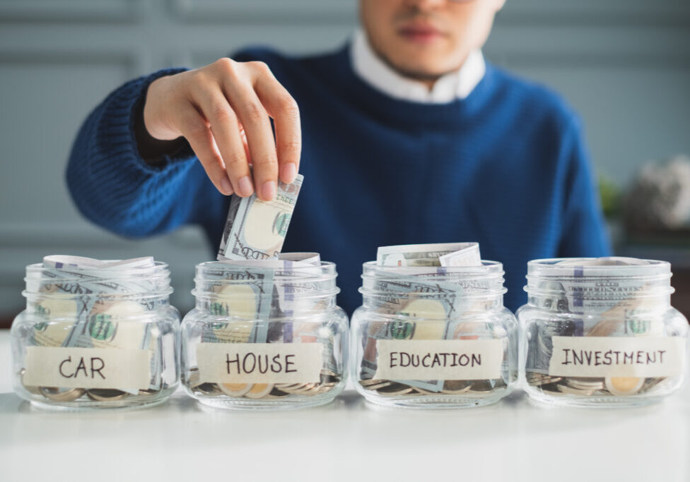 Hand's man putting money in jar for future, money plan, save money and management concept